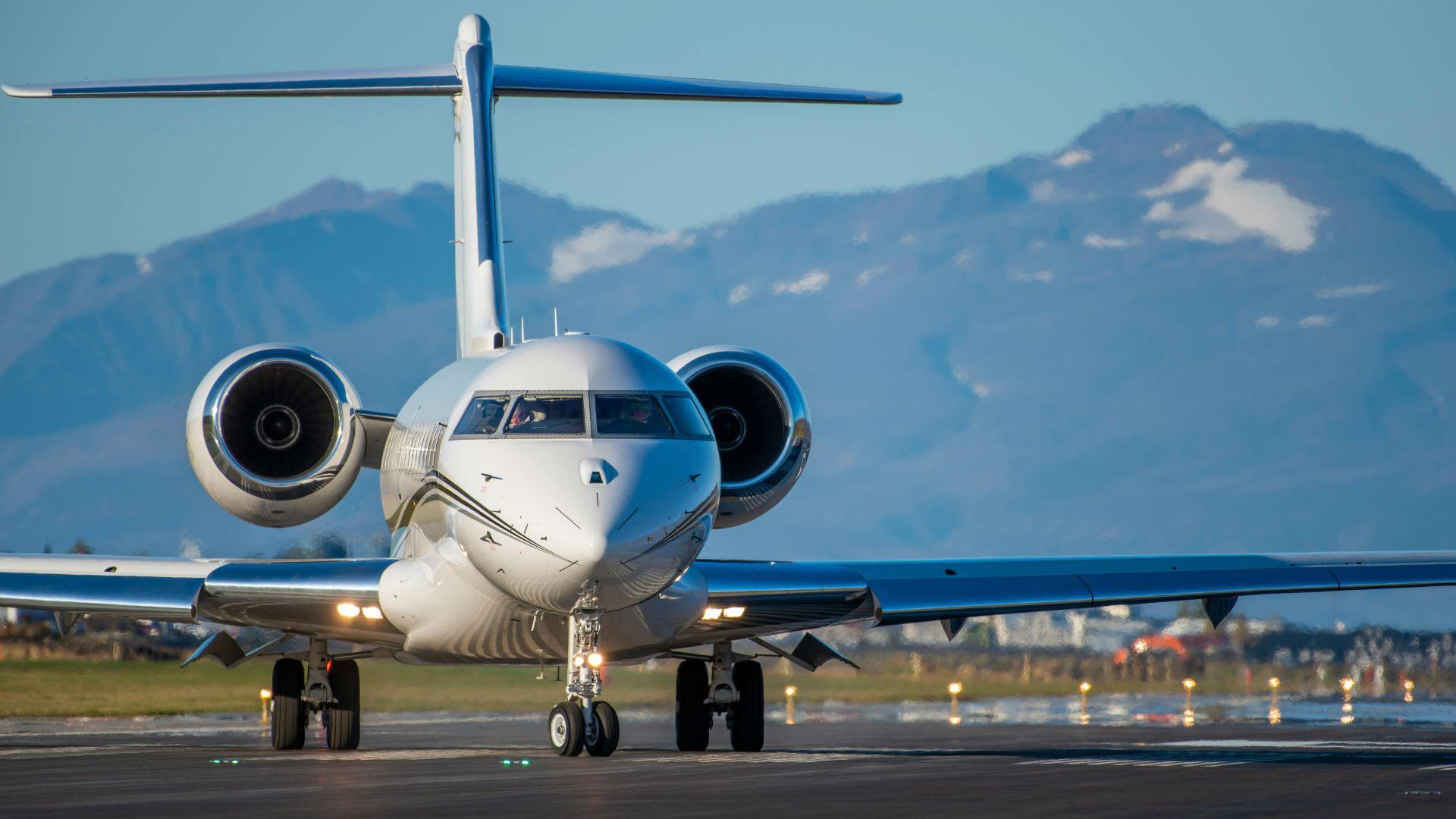Private jet taxiing on an airport runway at golden hour